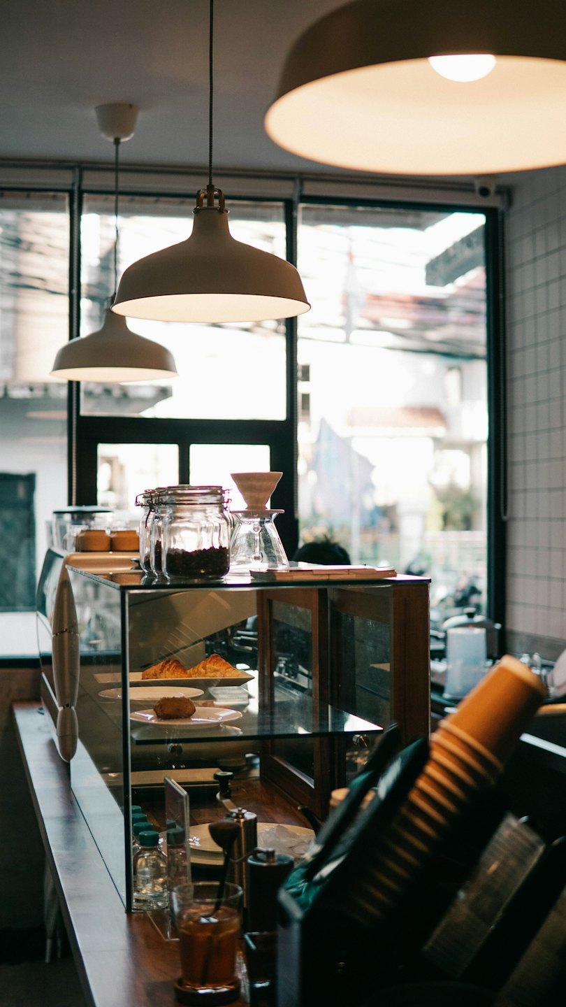 Pastries and coffee making supplies on a shop counter.