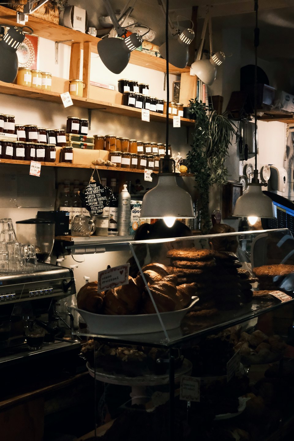 Cafe counter stocked with pastries, jars of preserves, and espresso machine.